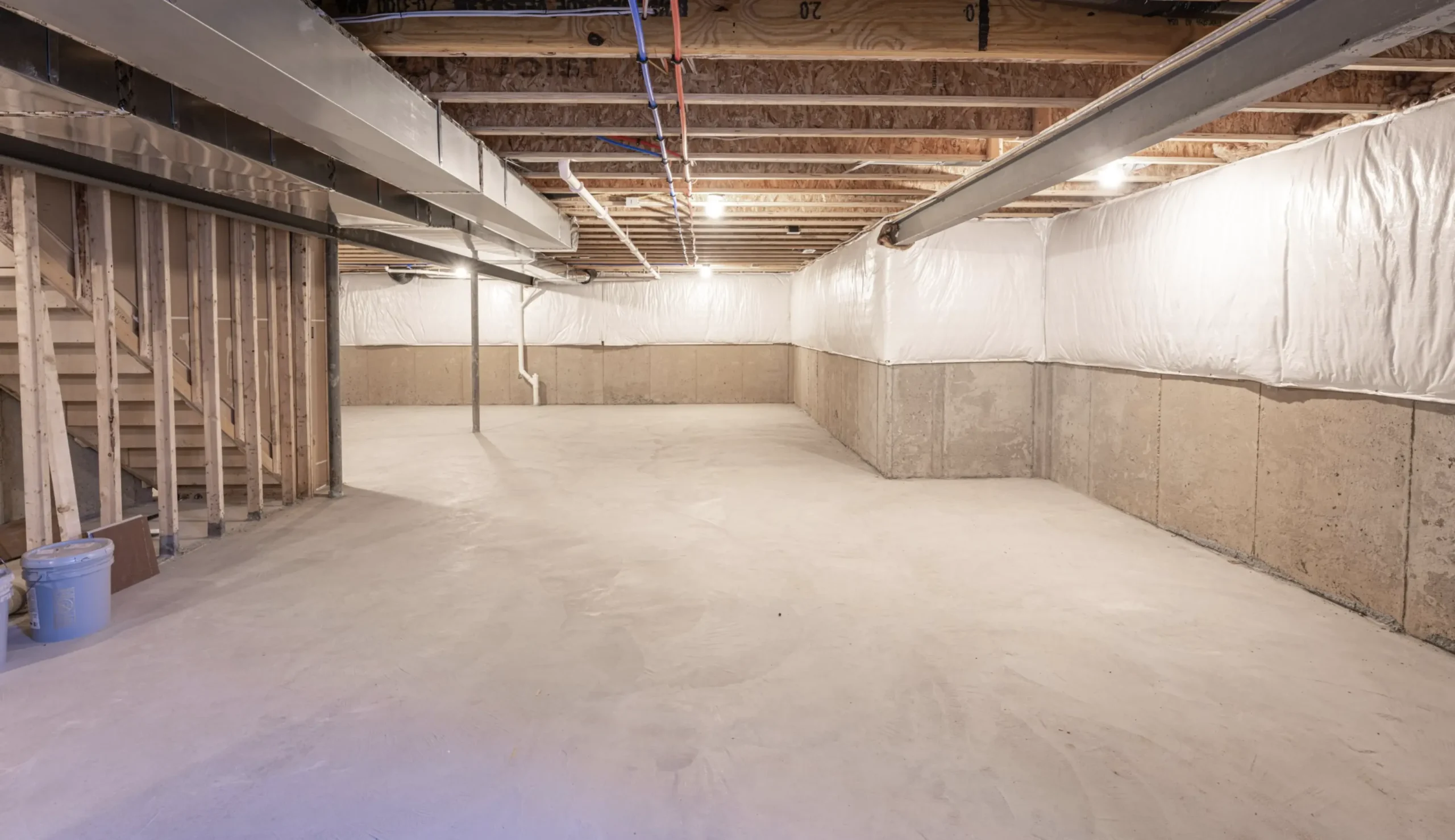 Finished basement with sealed walls and a clean floor after completed work