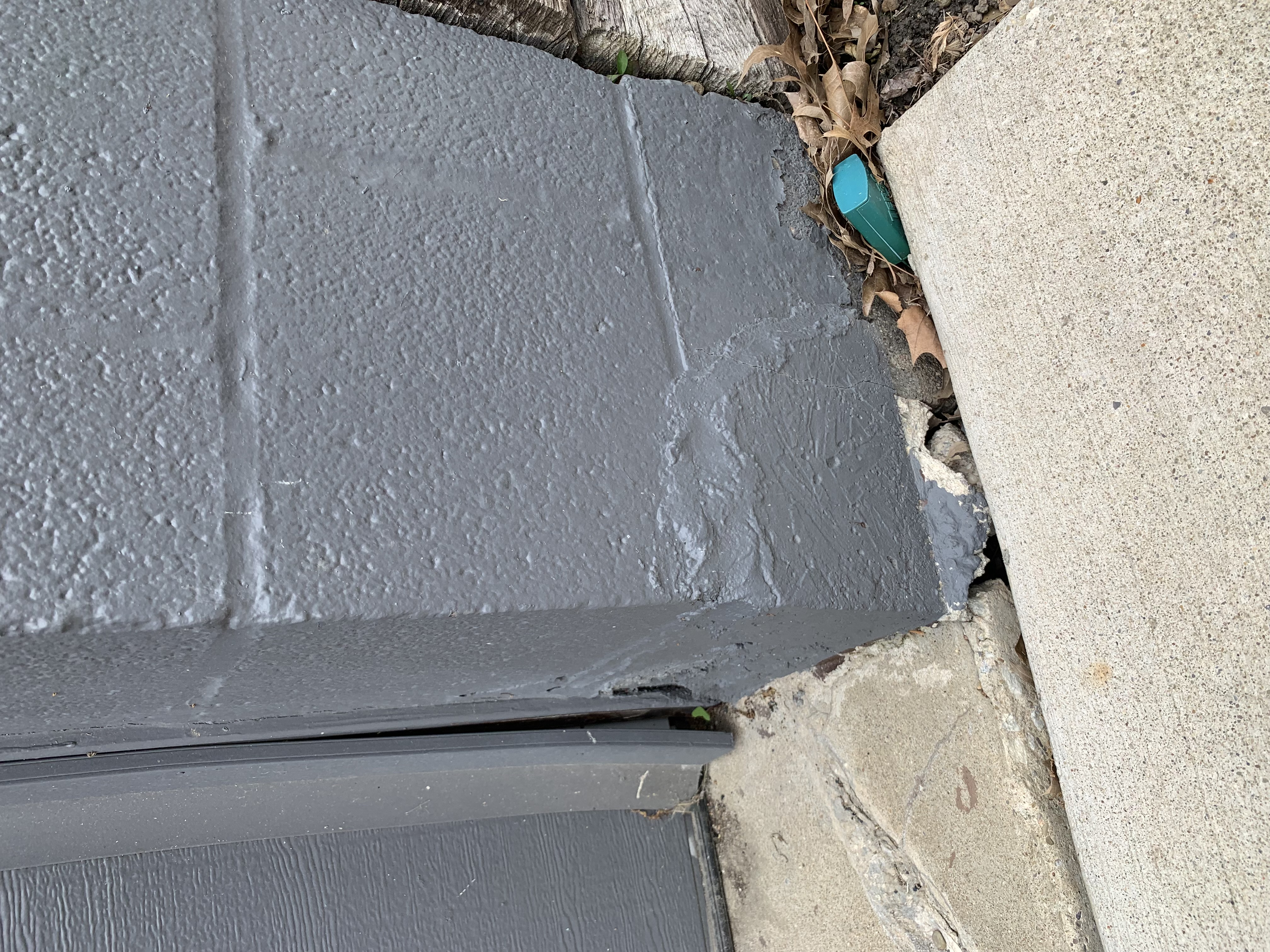 Gap where a settled slab meets the house during a foundation inspection