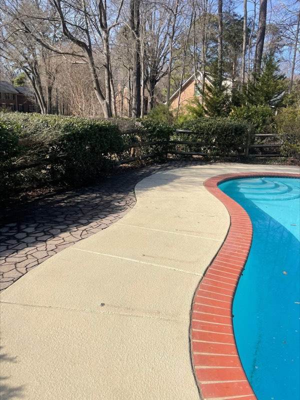 Settled pool deck concrete slab tilting away from the pool edge