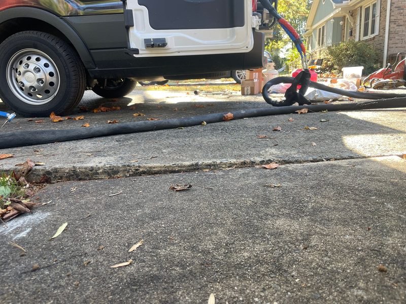 Sunken driveway slab creating a lip and water pooling near a garage entrance