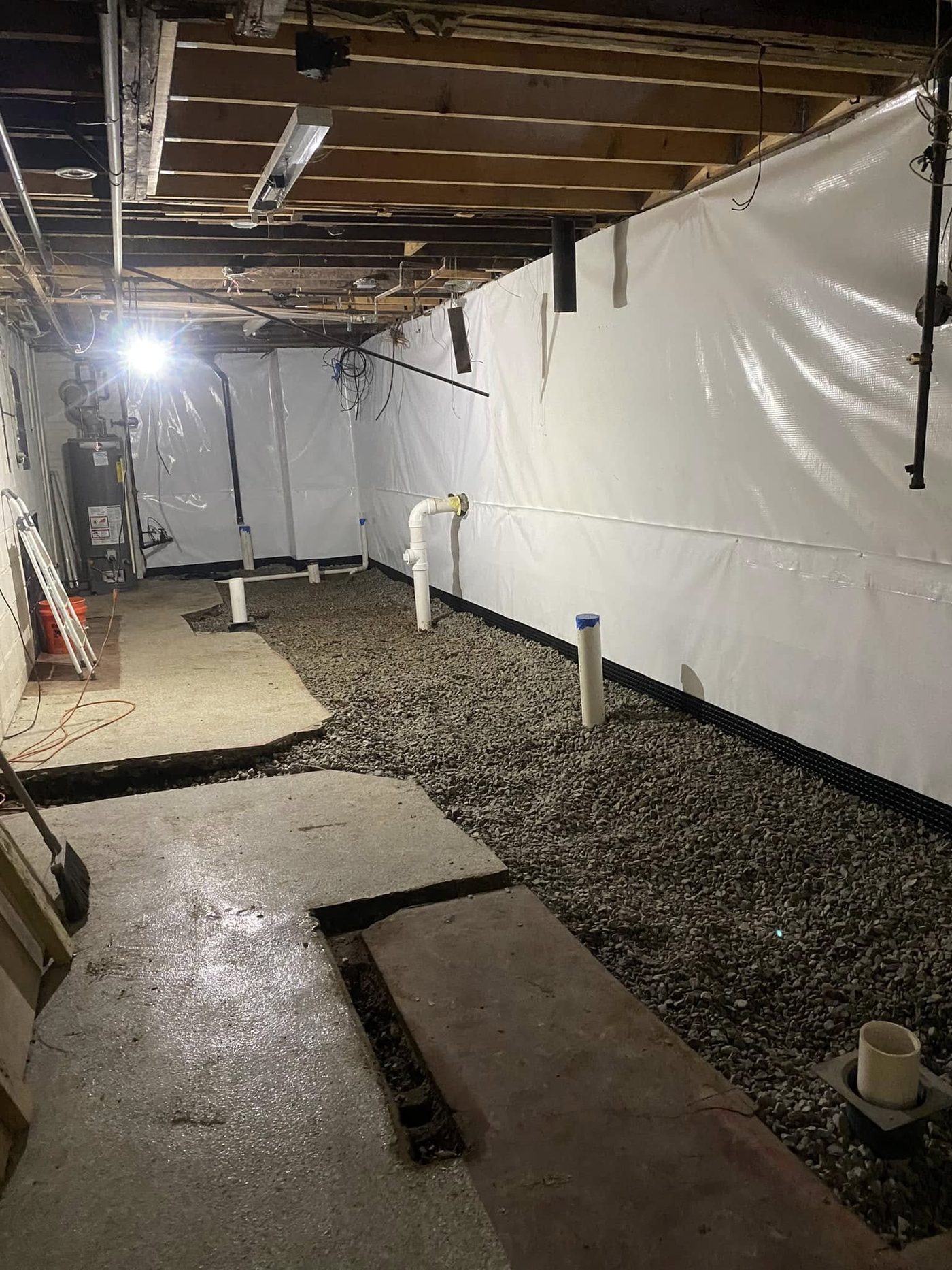 Interior basement waterproofing system with perimeter drain and vapor barrier