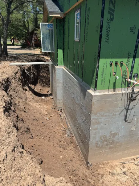 Exterior excavation exposing foundation wall for waterproofing and drainage installation